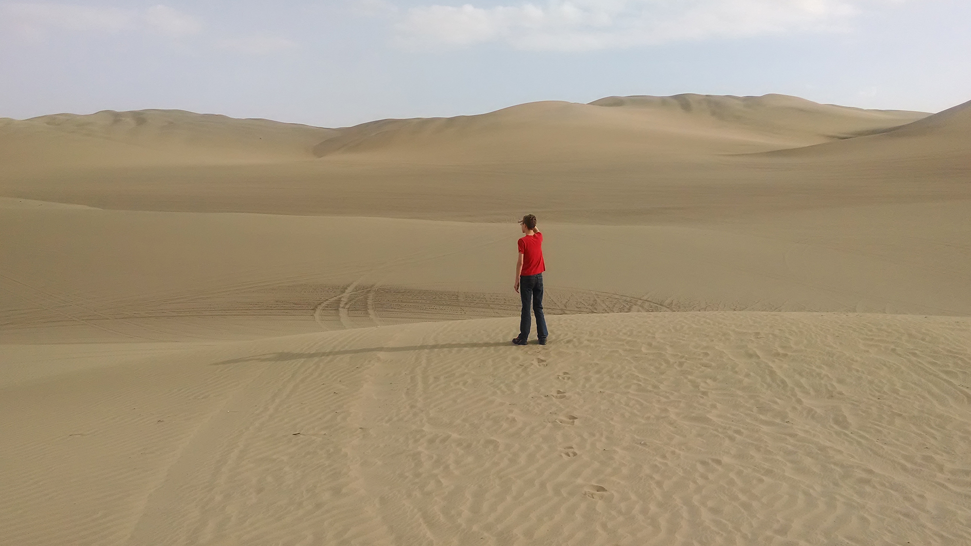 Lone man standing in vast desert