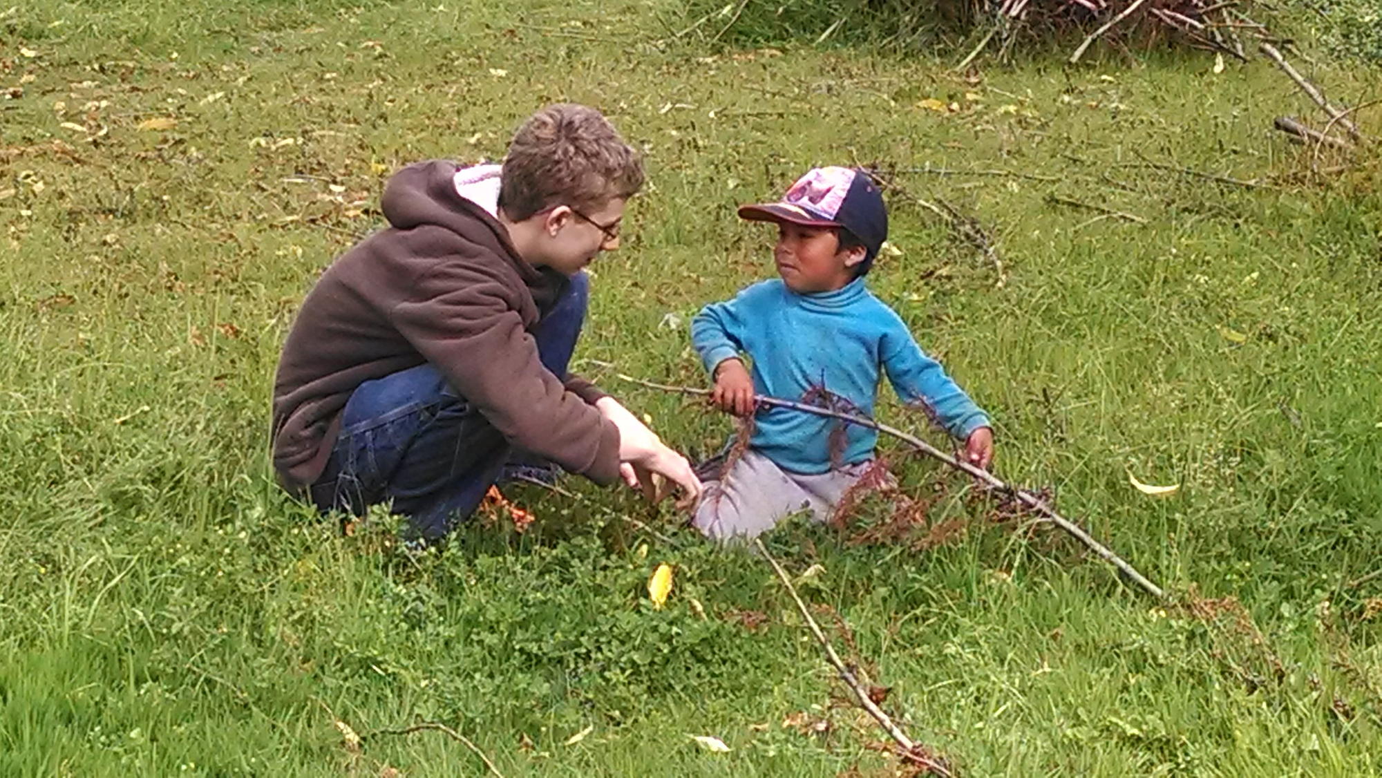 Two young boys talk in a field